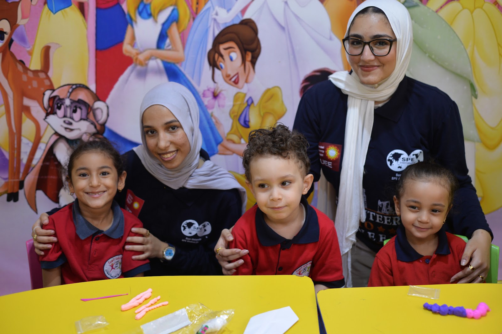 Volunteers mentoring young students in classroom